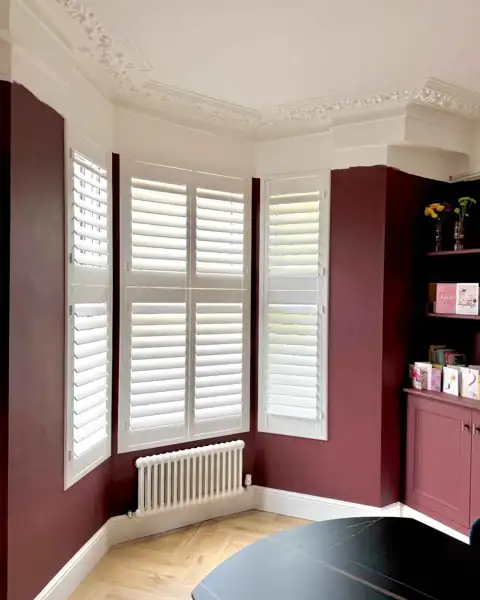 Hardwood shutters fitted in a bay window