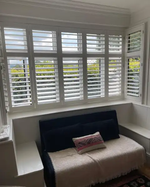 Full height hardwood shutters on a box bay