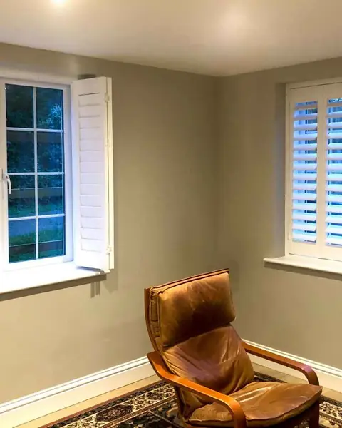 Hardwood shutters in a home study with a leather chair