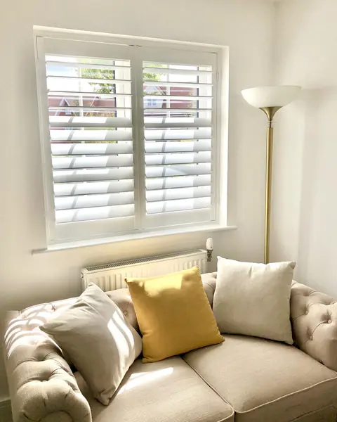 Hardwood shutters behind a cream sofa in a living room
